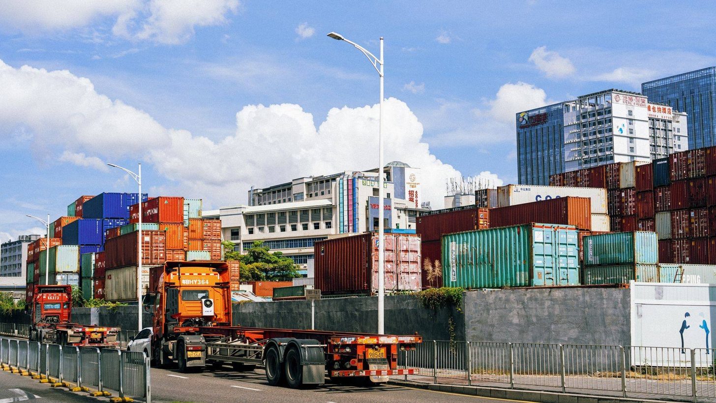 Camion porte-conteneurs quittant un parc à conteneurs