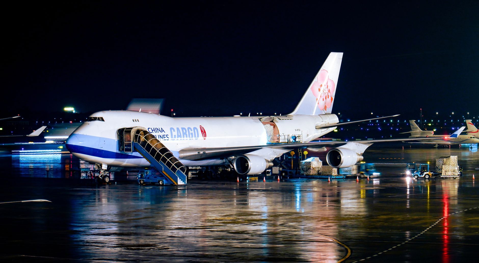 Avião de carga em operação nocturna num aeroporto iluminado