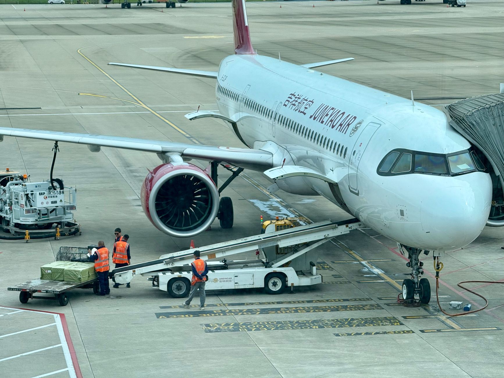 Pessoal de terra a preparar um avião para carga no terminal
