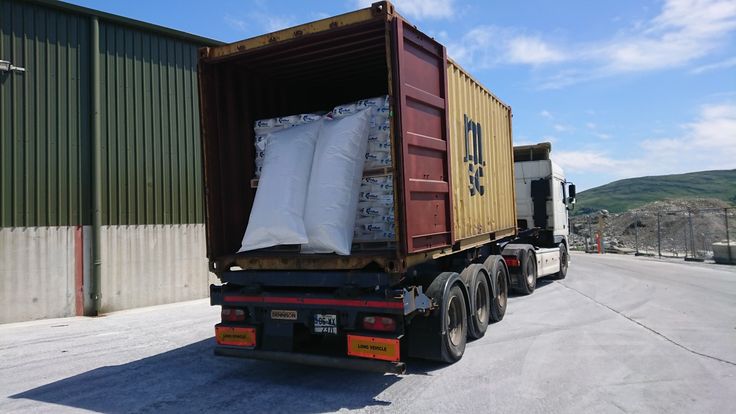 Camião com contentor aberto, carregado com mercadoria embalada