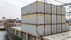 Contentores empilhados junto ao cais de um porto