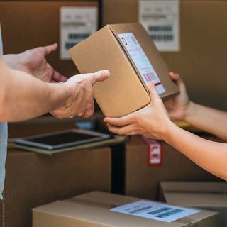 Entrega de uma encomenda embalada entre duas pessoas